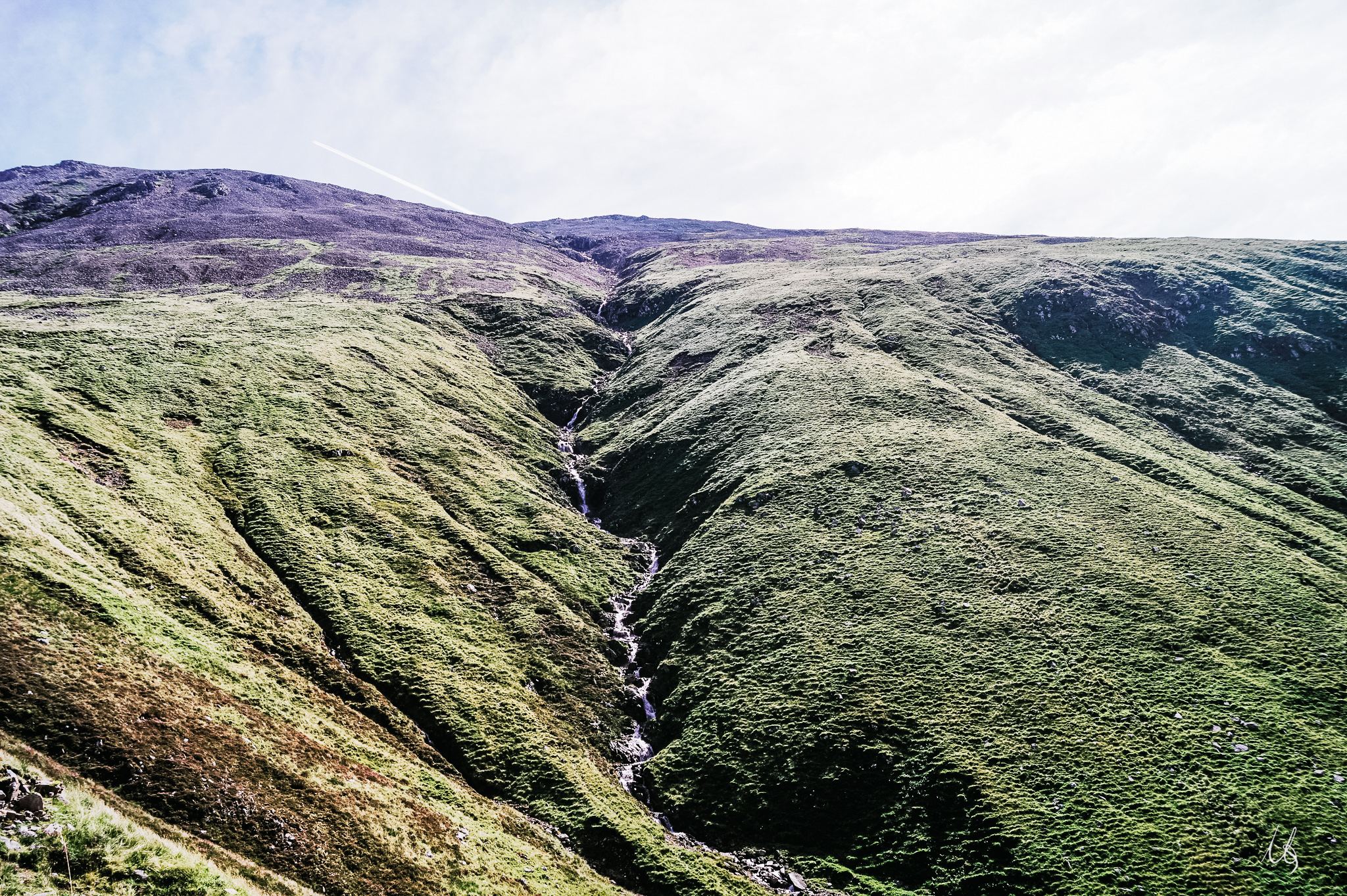 Ein Bach gräbt ein Tal durch die Highlands